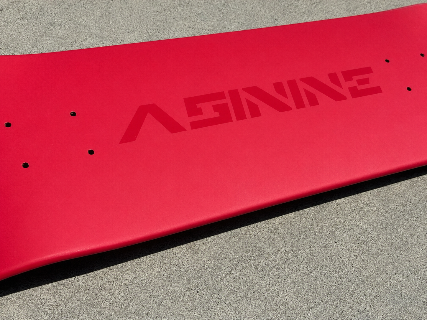 Close-up of an Asinine Skateboards deck featuring the high-gloss  logo and satin finish, representing quality craftsmanship and dependable performance.